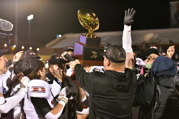 Washington players celebrate after being awarded the Class 2A state championship trophy on Dec. 9, 2023.
